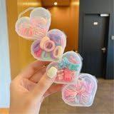 A set of hair ties with 4 transparent heart-shaped storage cases
